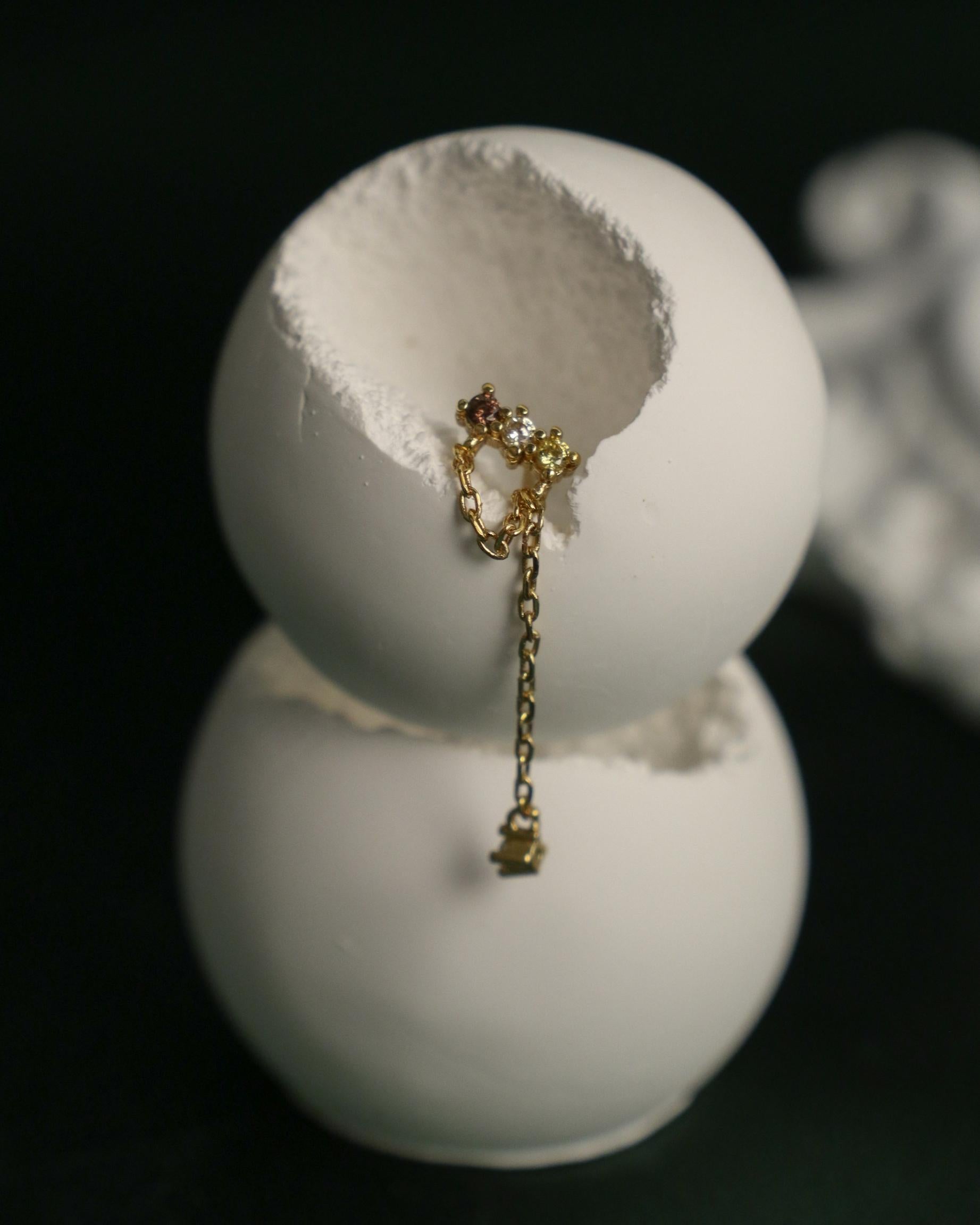 close up of dangling chain and zirconia earrings