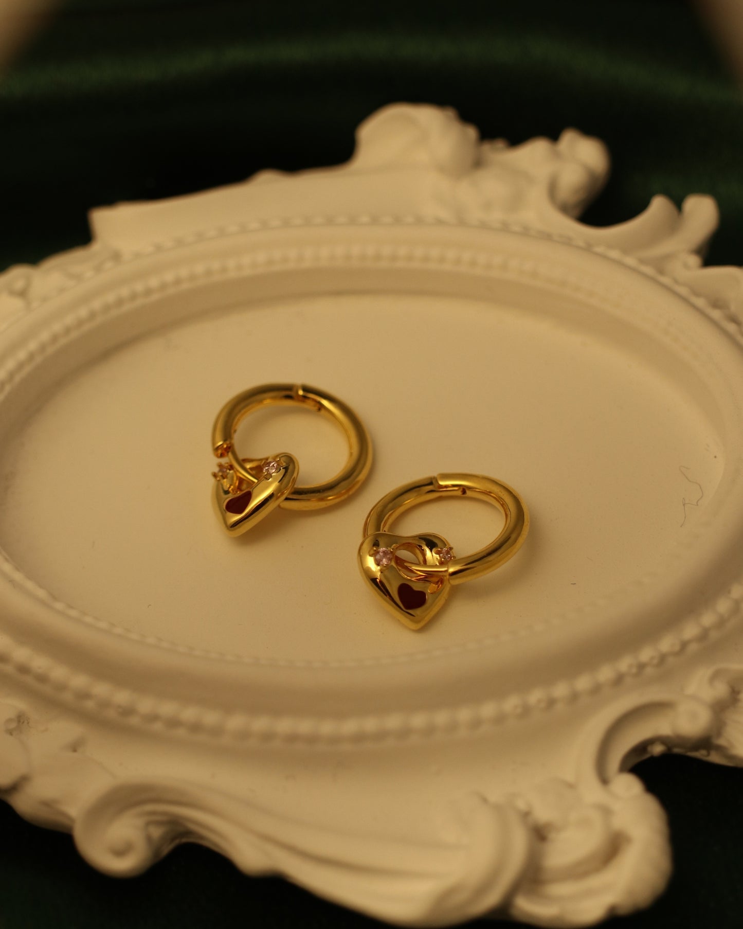close up of gemstone heart charm huggie earrings