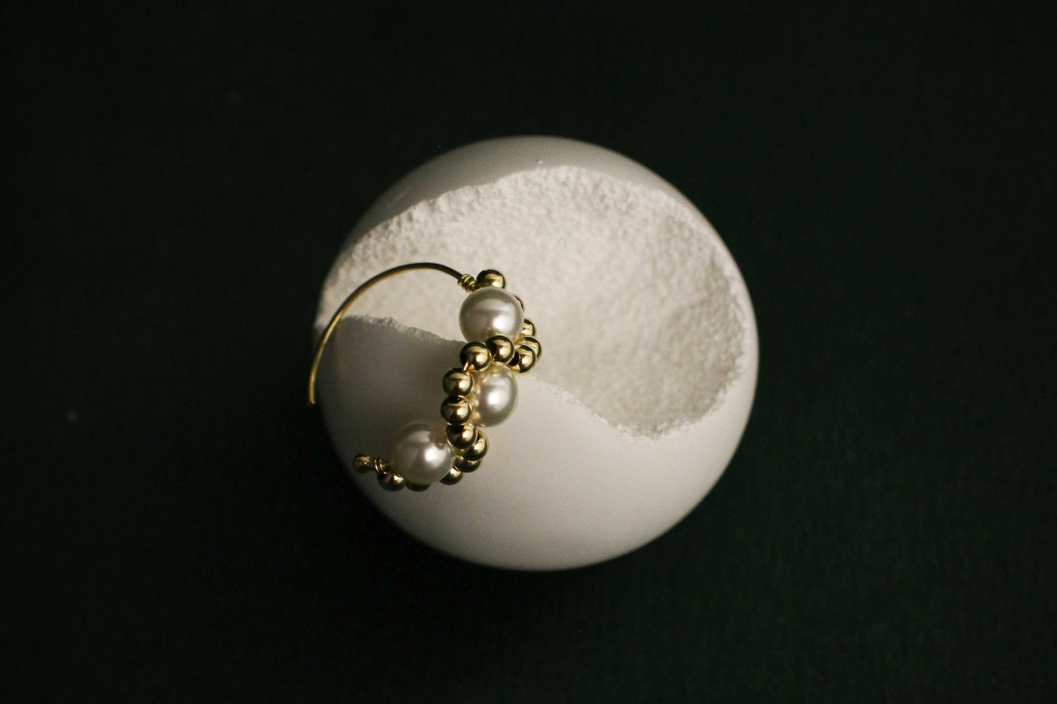 Single pearl earring on display rock