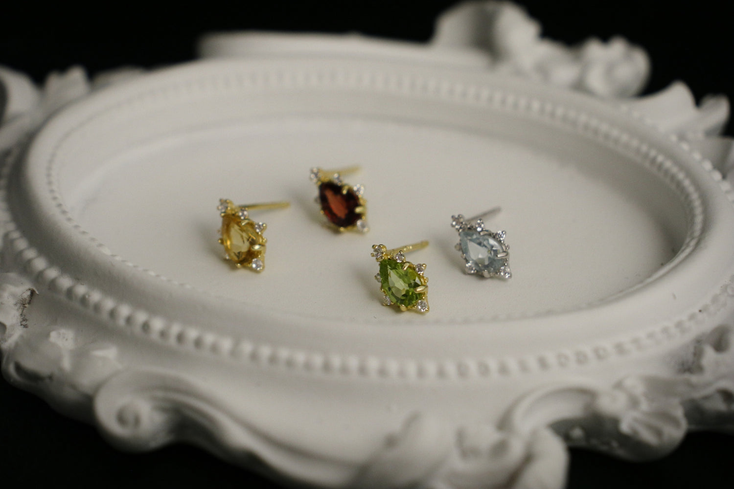 four pieces of crystal earrings on display plate