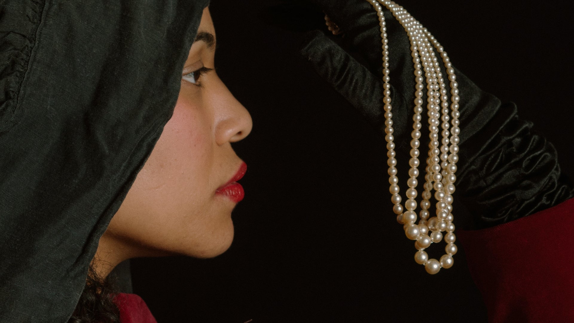 woman holding pearl necklaces