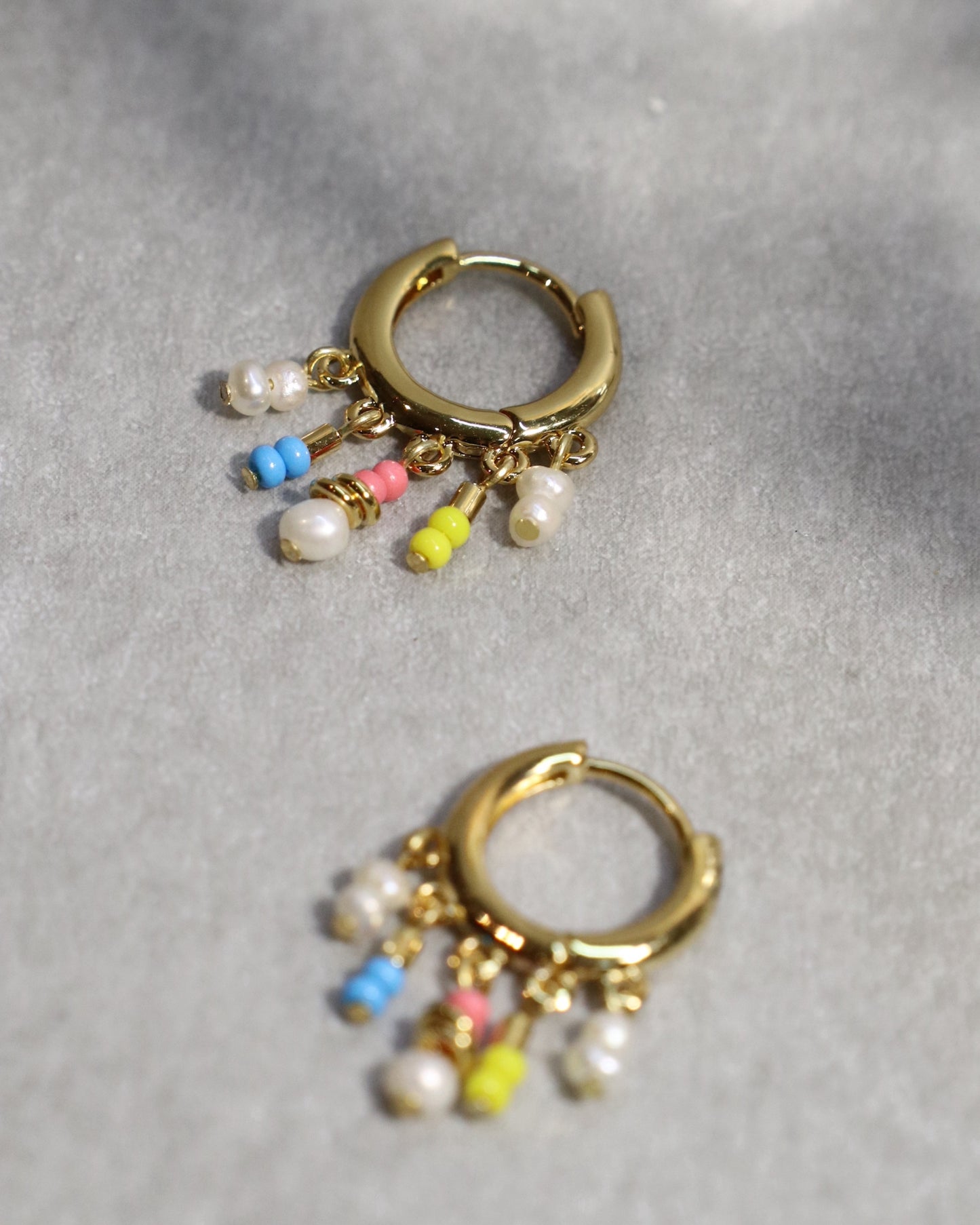 close up of drop bead huggie earrings