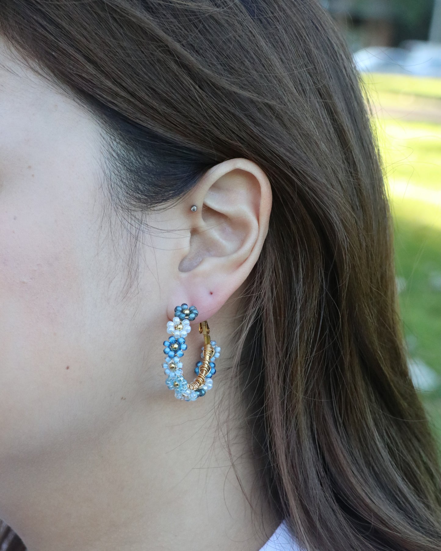 woman wearing floral beaded hoop earrings