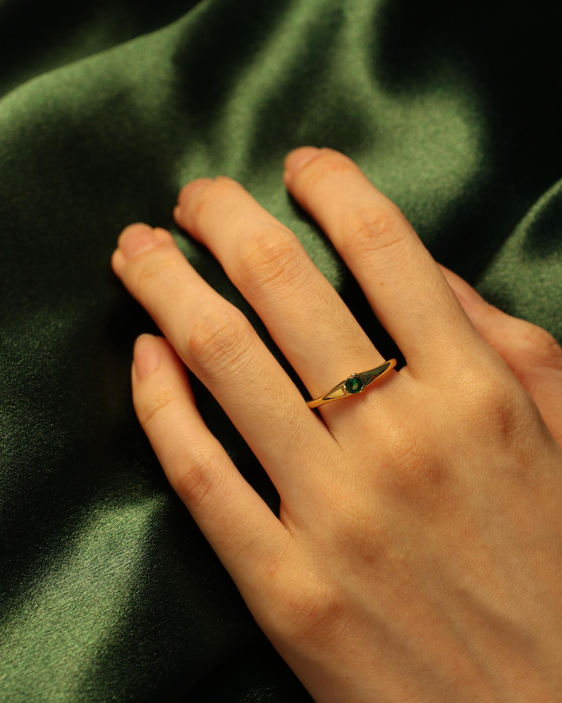 woman wearing green gemstone rings
